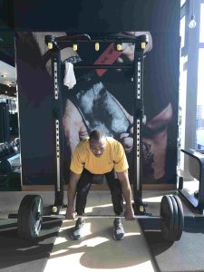 Person lifting weights in a gym as part of an advanced strength training program