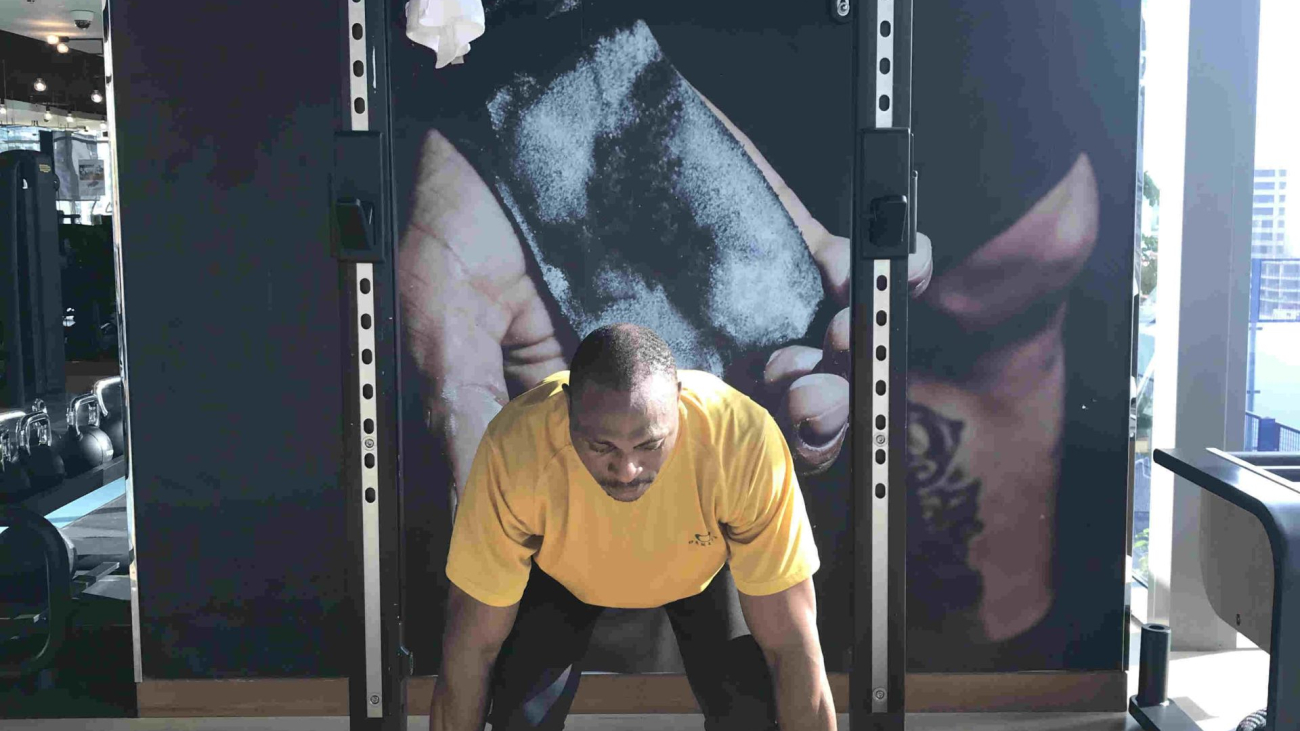 Person lifting weights in a gym as part of an advanced strength training program